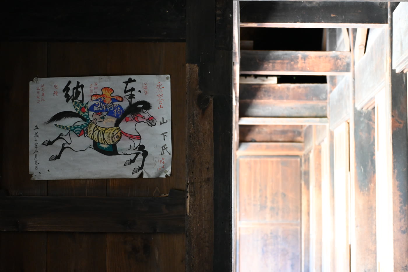 Painting of a galloping horse pinned to a dark wooden wall